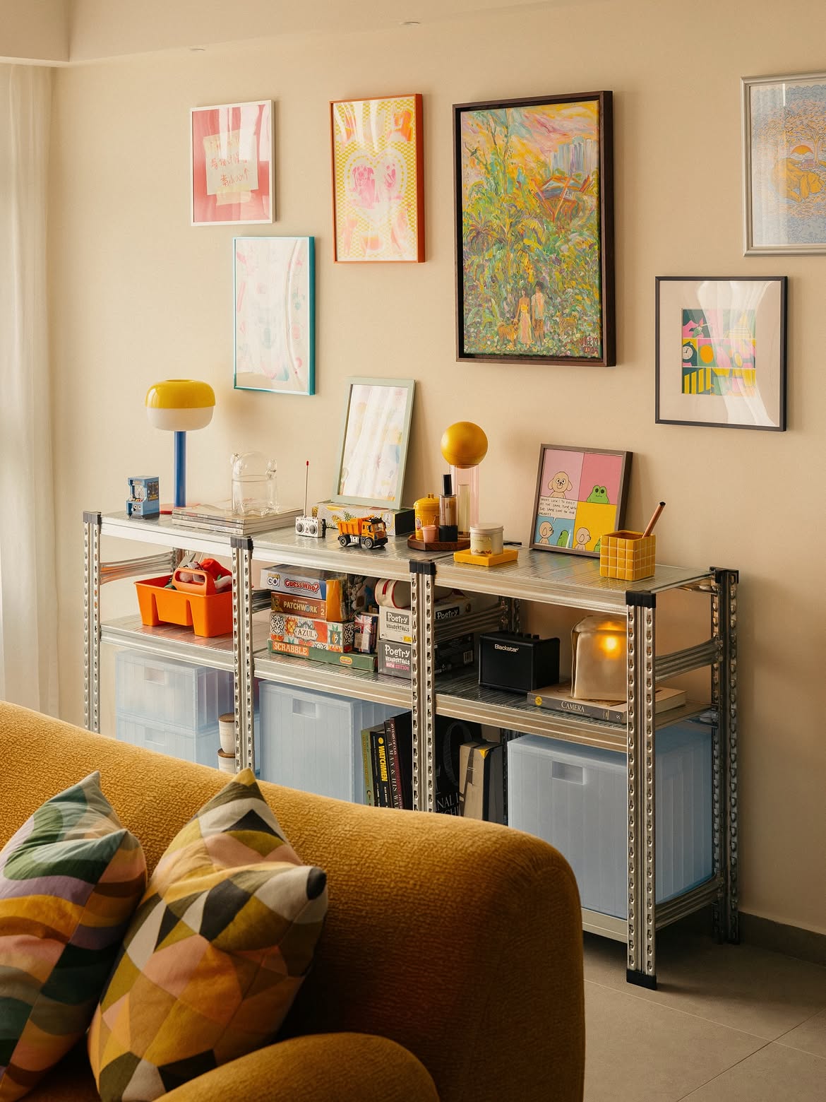Maed Studio’s eclectic retro sofa styling showing a colourful gallery wall of vibrant framed art and prints.